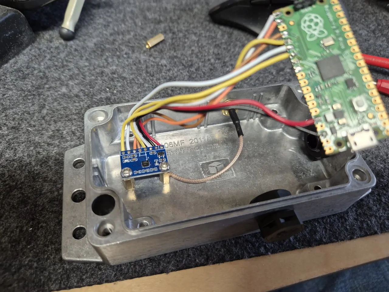 The breakout board on brass standoffs inside the open box, with the PPS coax running to the SMA connector